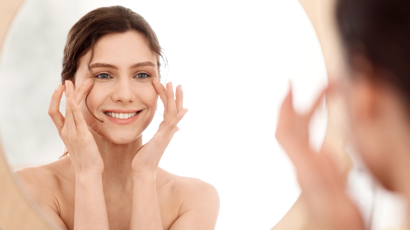 鏡を見ながらマッサージをしている女性