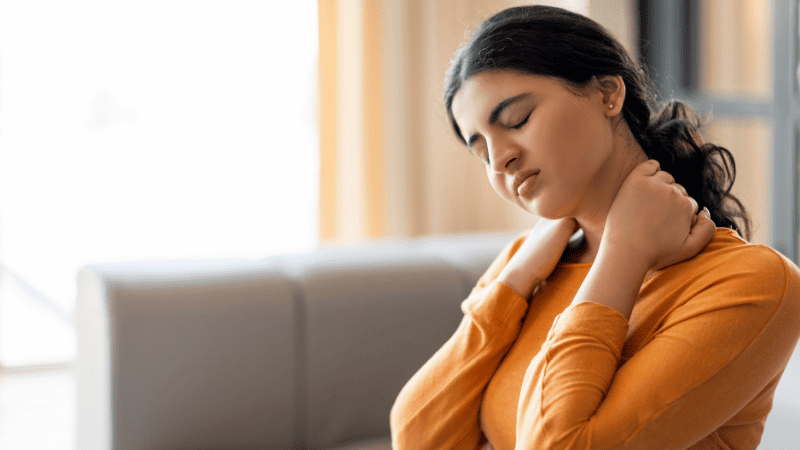首の凝りを感じる女性