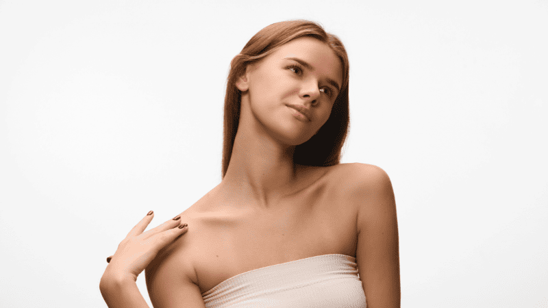 デコルテを出して方に手を置く女性