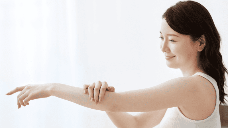 腕をマッサージする女性